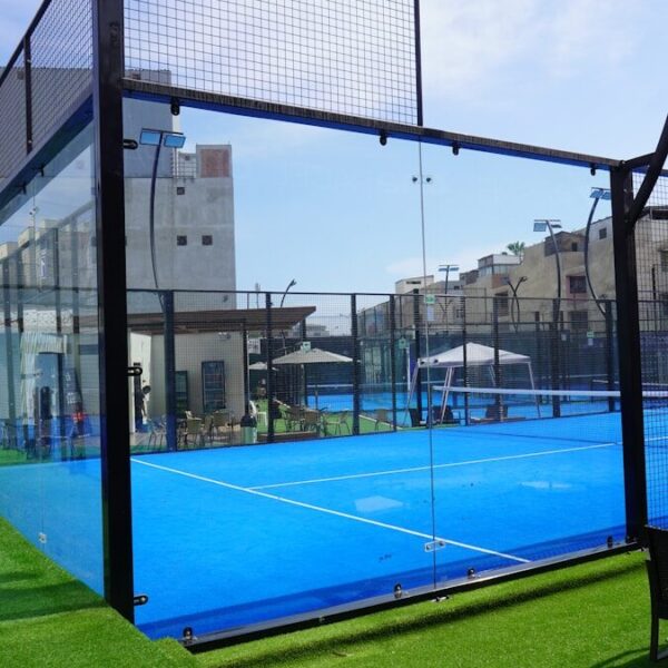 Close-up van de metalen kooiconstructie en glazen wanden padelbaan