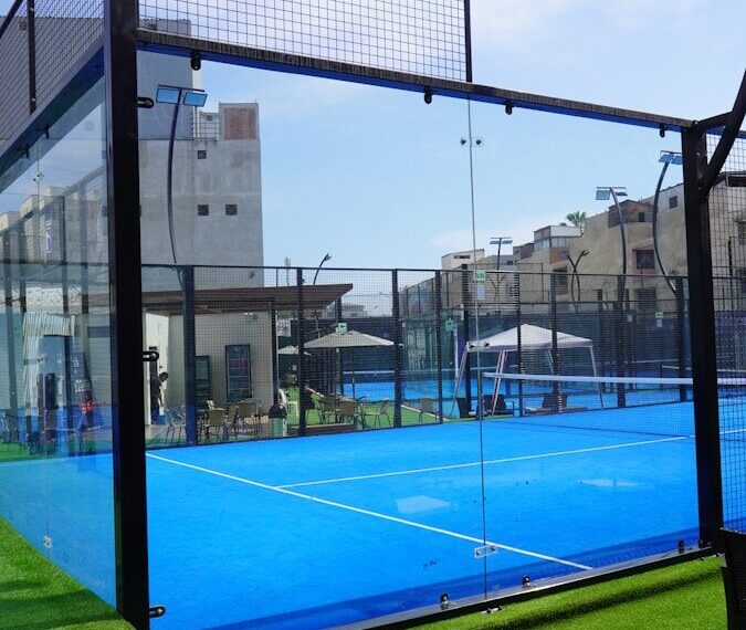 Close-up van de metalen kooiconstructie en glazen wanden padelbaan