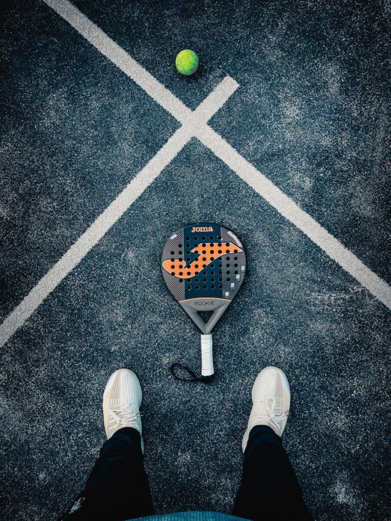 Padelspelers demonstreren padel tactisch spel door strategische netpositionering tijdens een volle rally.